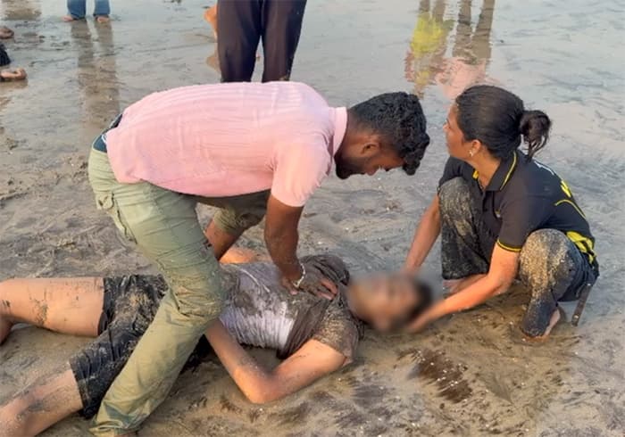 Raigad: A person is attended to by people after being pulled out of the water at Diveagar beach in Raigad district of Maharashtra on Thursday, October 1, 2026. (Photo: IANS/Video Grab)