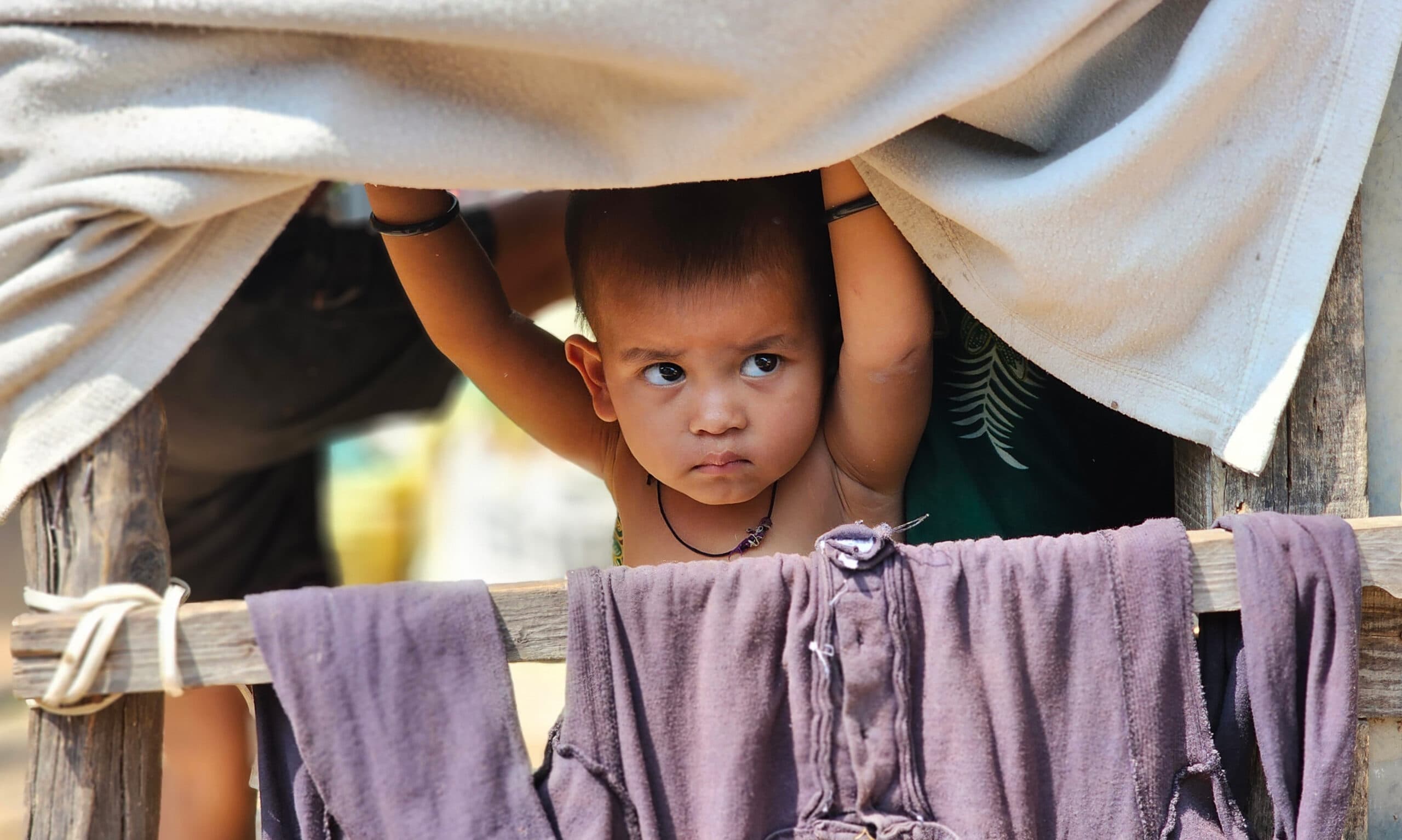 Jammu: A Rohingya child looks out from a makeshift shelter amid concerns over possible eviction following administrative action and verification of foreign nationals, in Jammu, Jammu and Kashmir, on Wednesday, September 16, 2026. (Photo: IANS)
